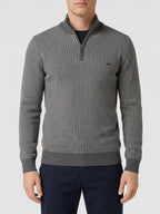 Model wearing a Brown knit quarter zip sweater with a textured knit pattern and ribbed mock neck in a front studio view.