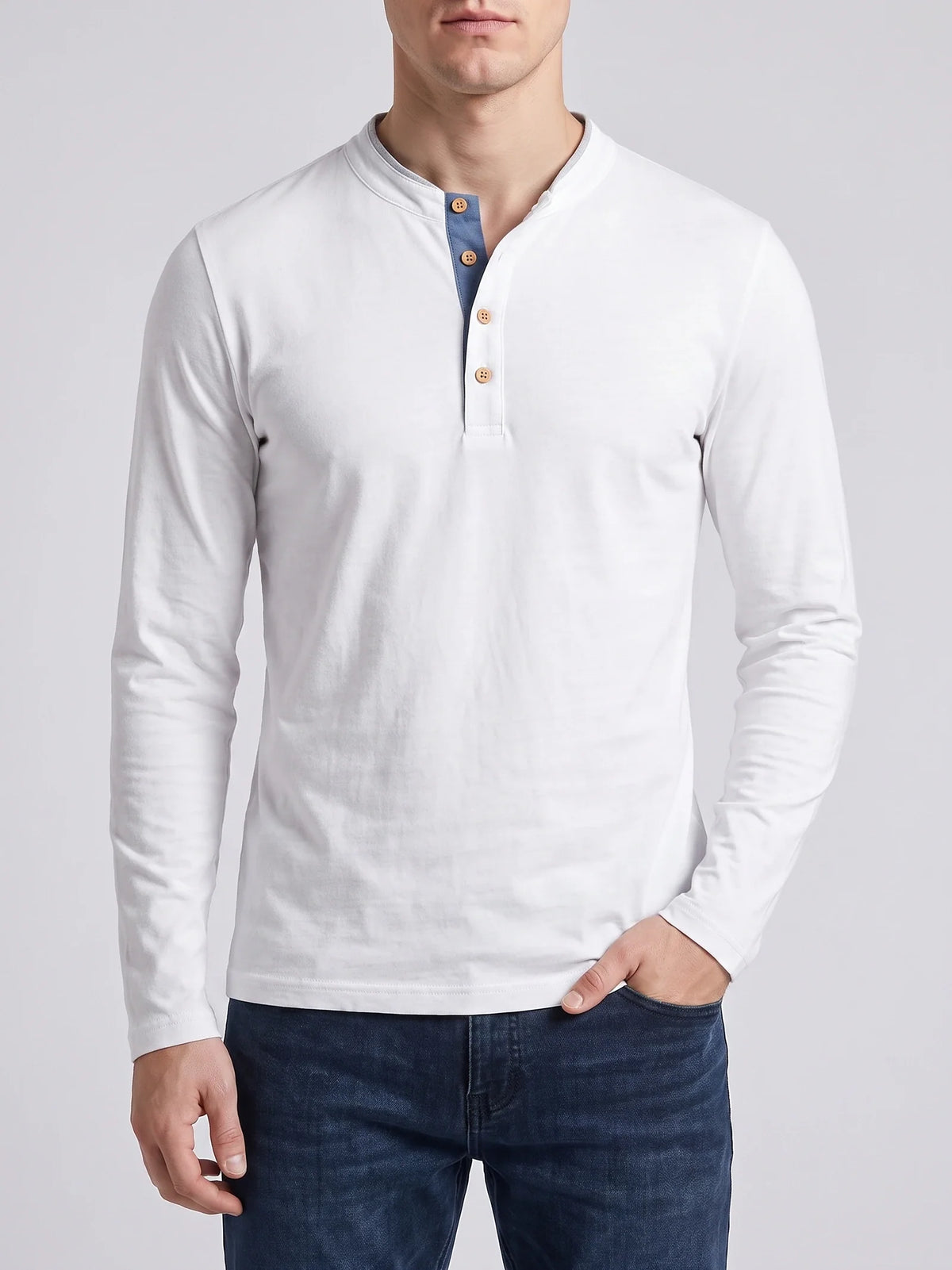 Model wearing a Blue Slim-Fit cotton long-sleeve Henley shirt on a sunlit garden patio beside a stone house.