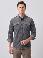 Model wearing a Gray Twill Tweed Shirt with button-flap chest pockets in a wood-paneled library.