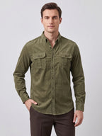 Model wearing a Navy Twill Tweed Shirt with rolled sleeves and flap chest pockets while walking beside a landscaped home.