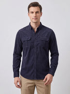 Close-up of the Blue Twill Tweed Shirt showing its ribbed cotton texture, pointed collar, button placket, and flap chest pocket.